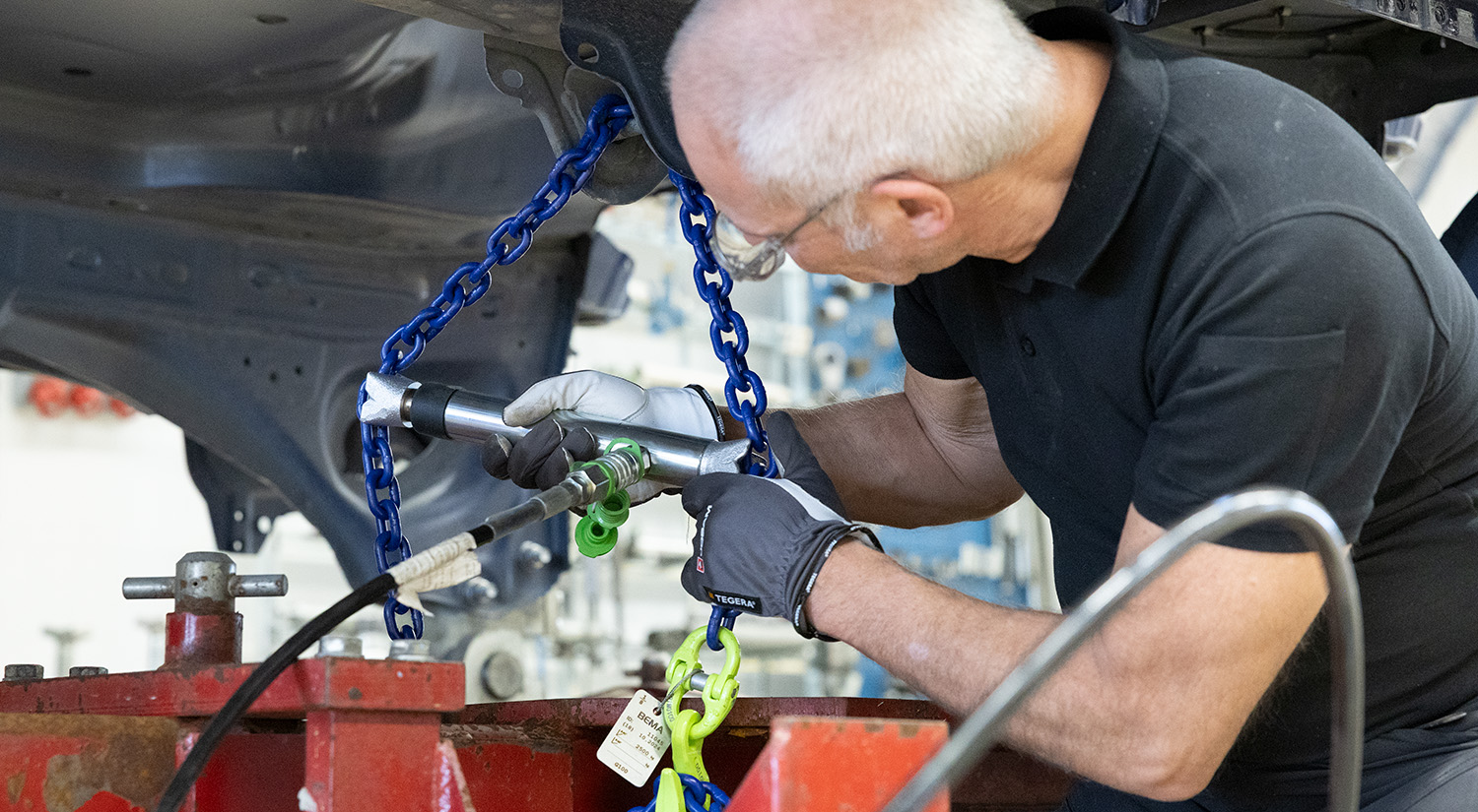 A technician using a hydraulic powered collision tool