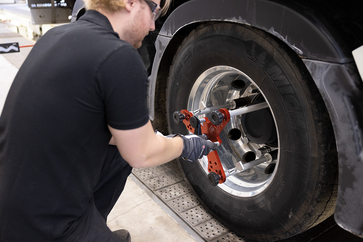 Technician attaching JOSAM wheel clamps to truck tire