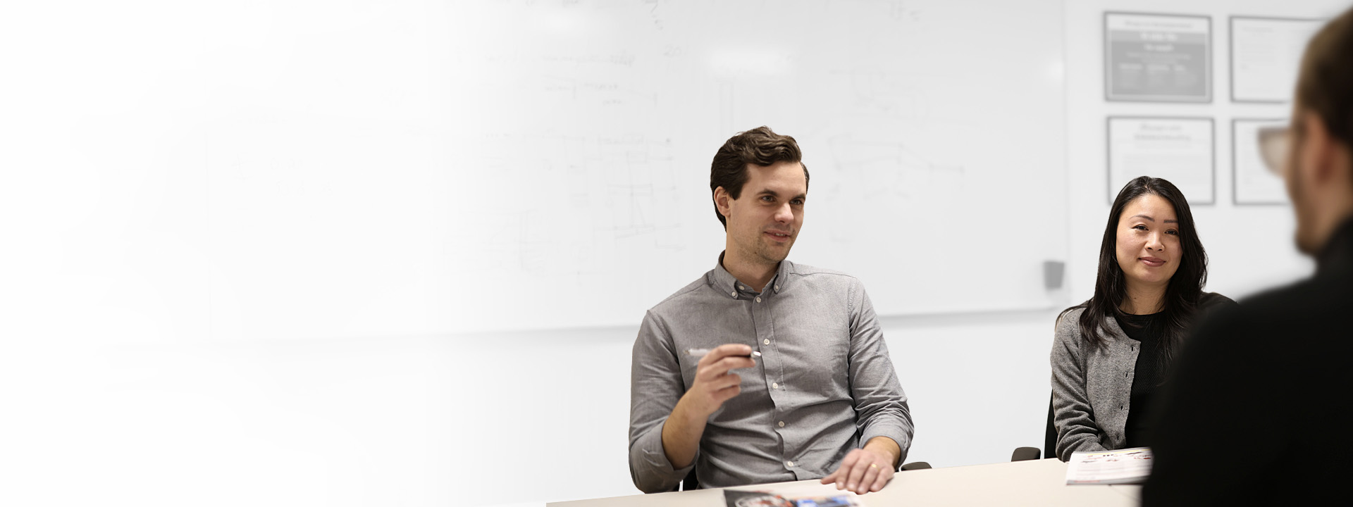 Three people conversing in a conference room