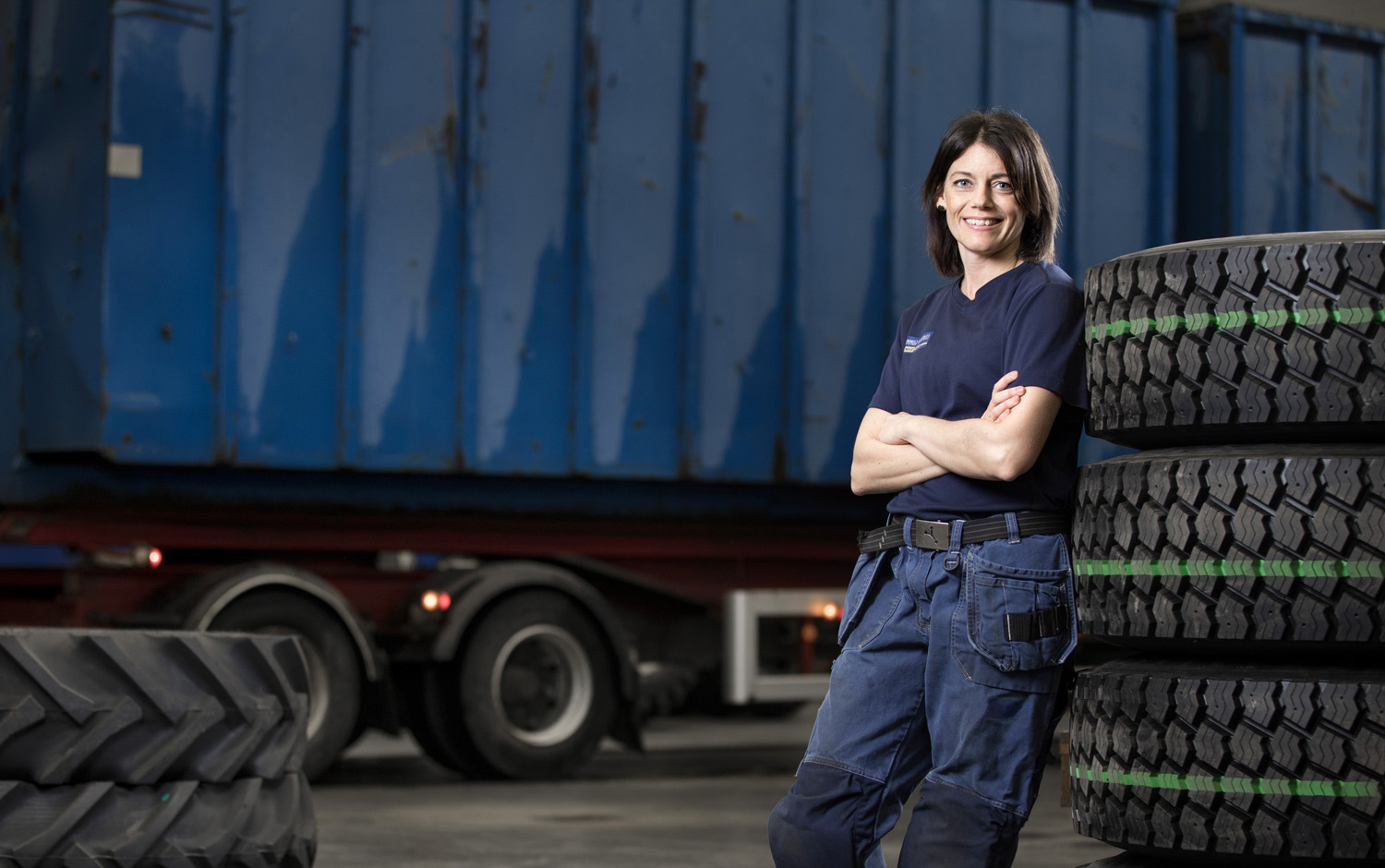 Woman standing near stack of large tyres