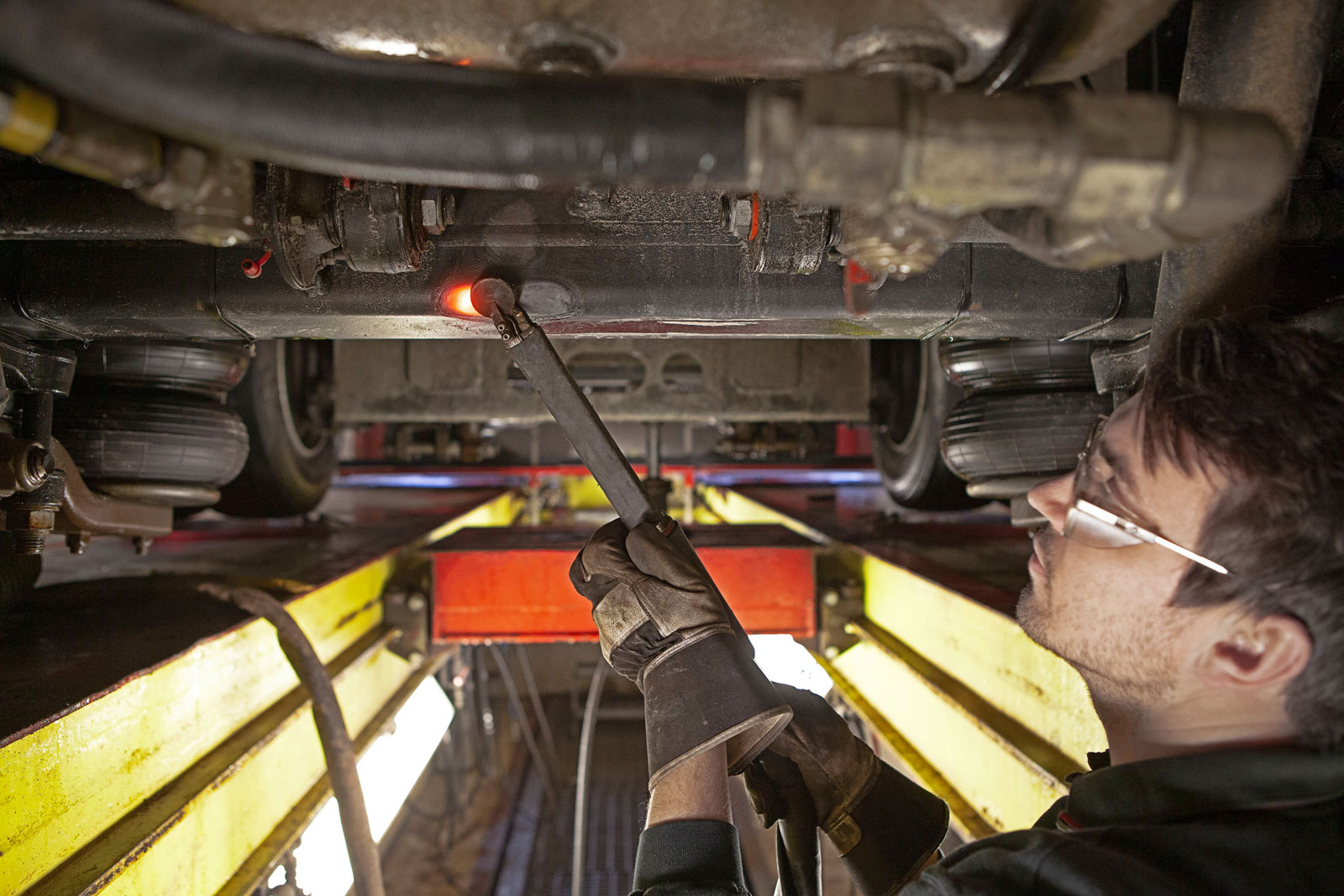A technician using JOSAM JH1000 induction heater to heat metal surface under a car