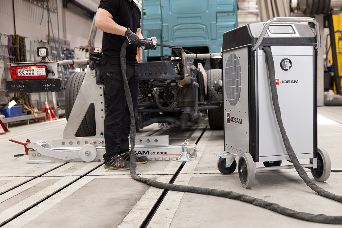 Technician using JOSAM JH1500 induction heater to heat part of a truck frame