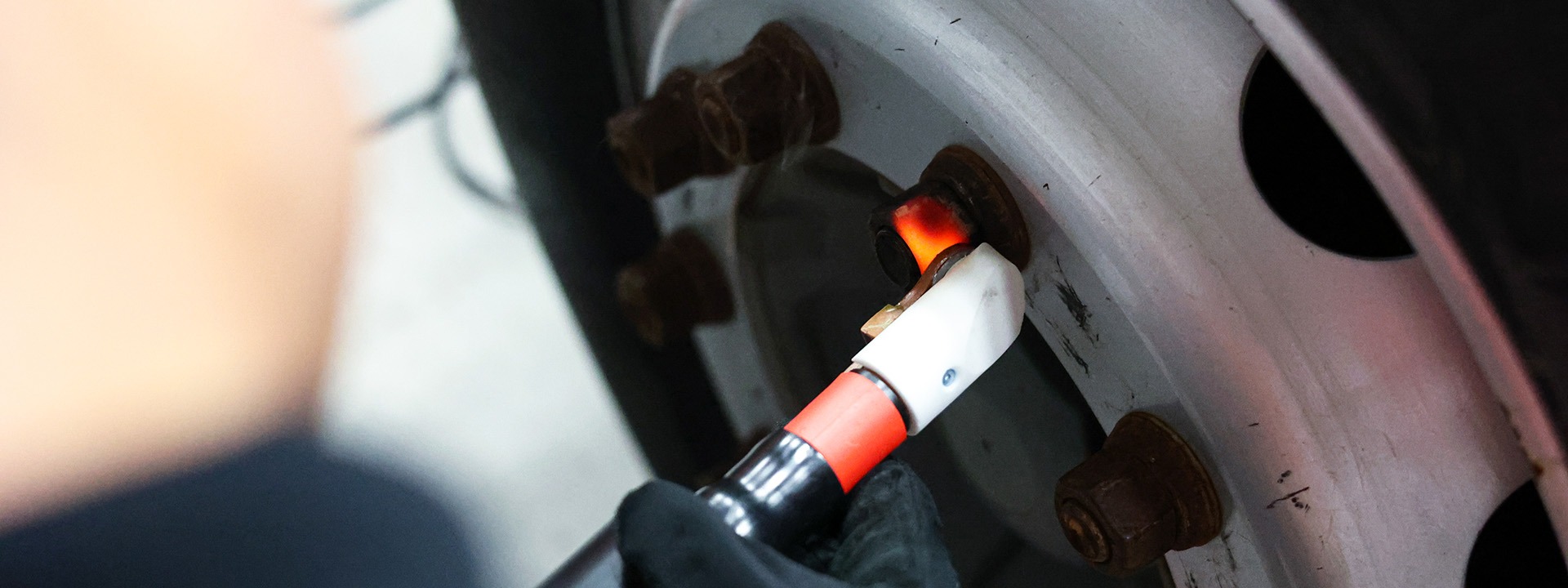 A technician using JOSAM JH400 induction heater to heat a bolt