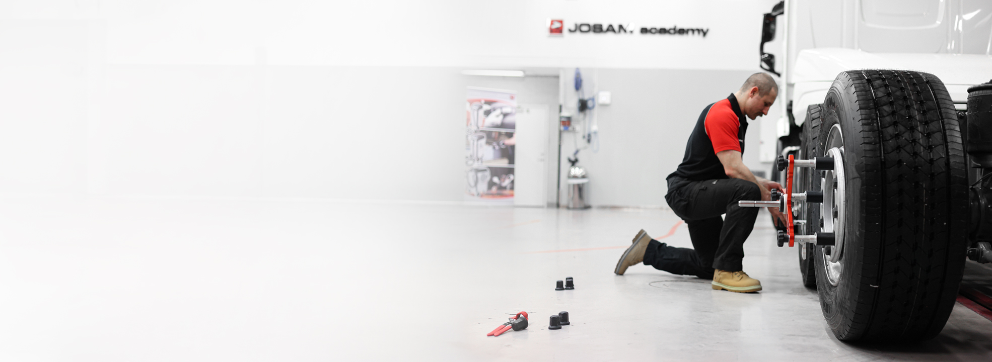 A technician working with JOSAM wheel alignment equipment
