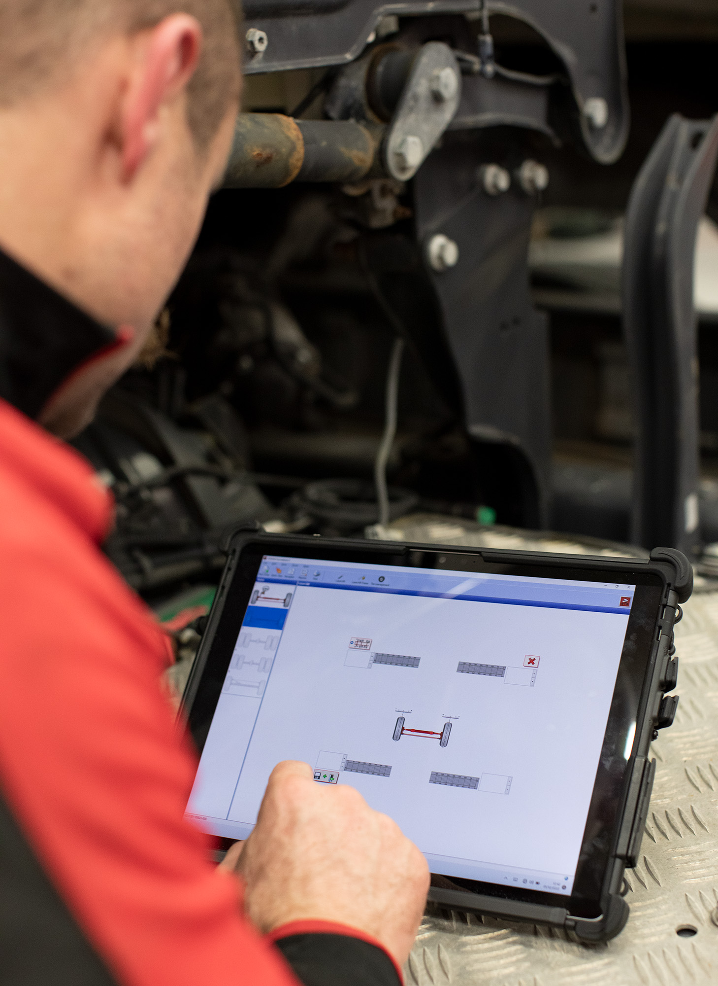 Technician using Josam wheel aligner on a tablet
