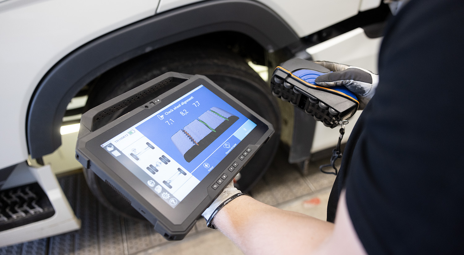 Technician using TreadReader to measure tire tread