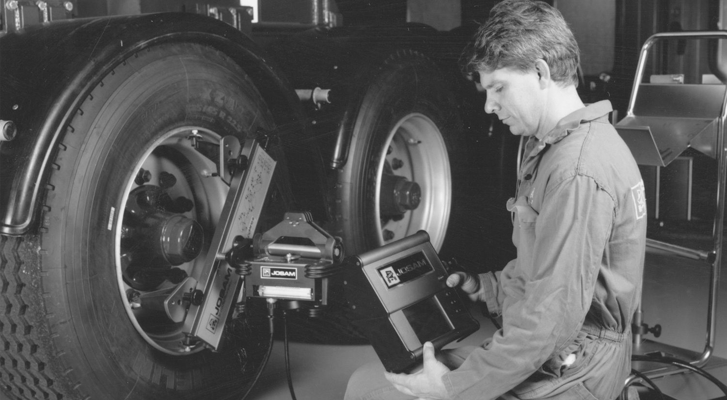 Technician performing wheel alignment using JOSAM equipment