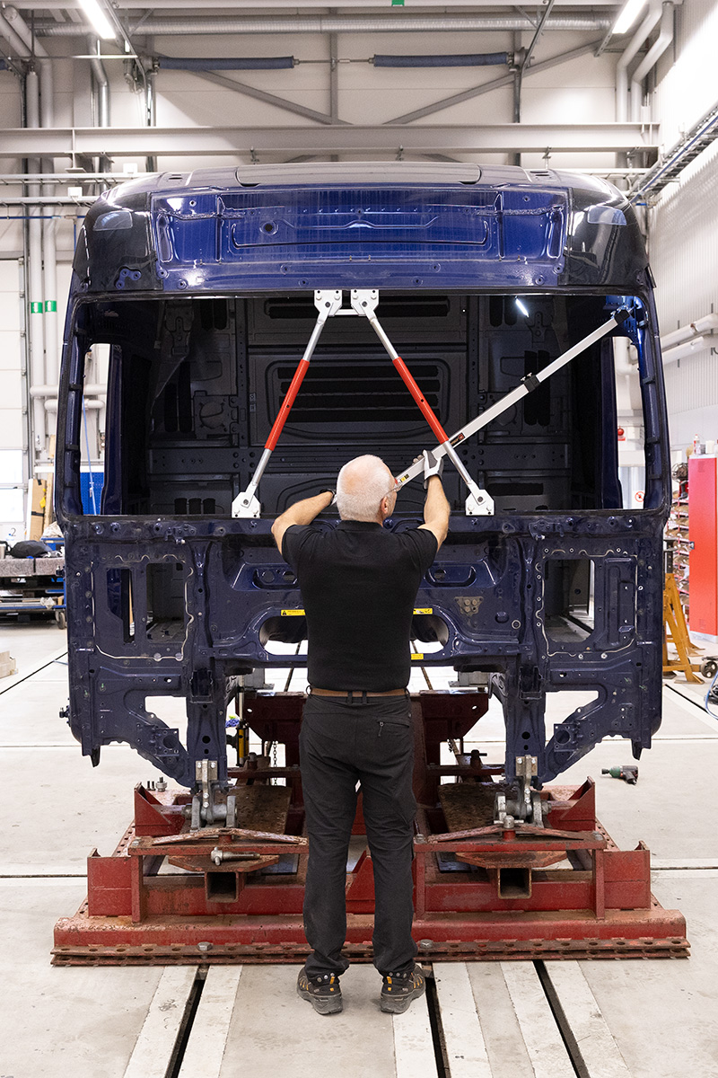 Technician working on a truck cab mounted on the JOSAM Cab Bench