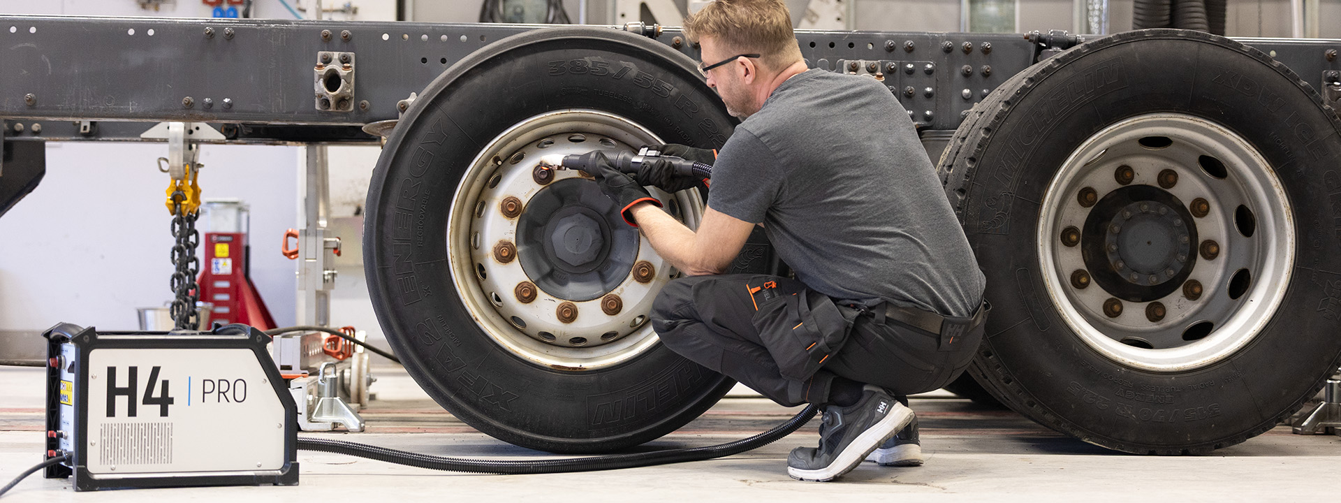 Technician using H4 Pro induction heater to heat bolt on a truck tire