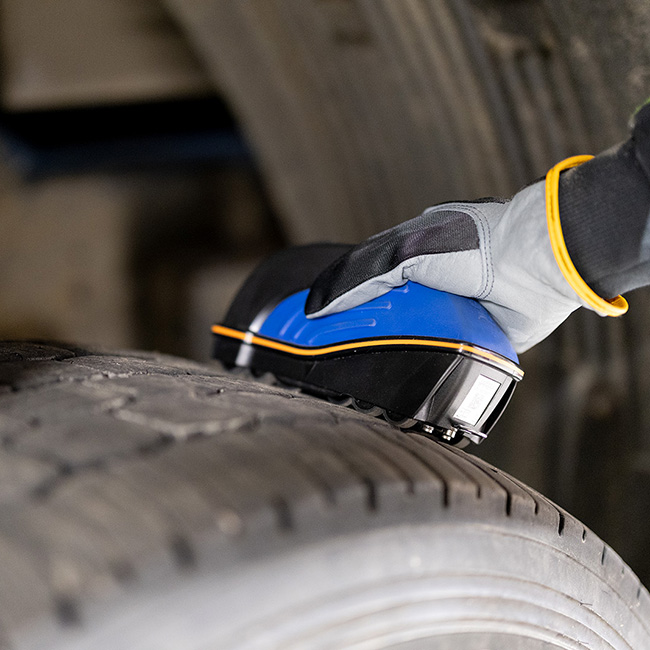 A TreadReader being used to scan a tire's treads
