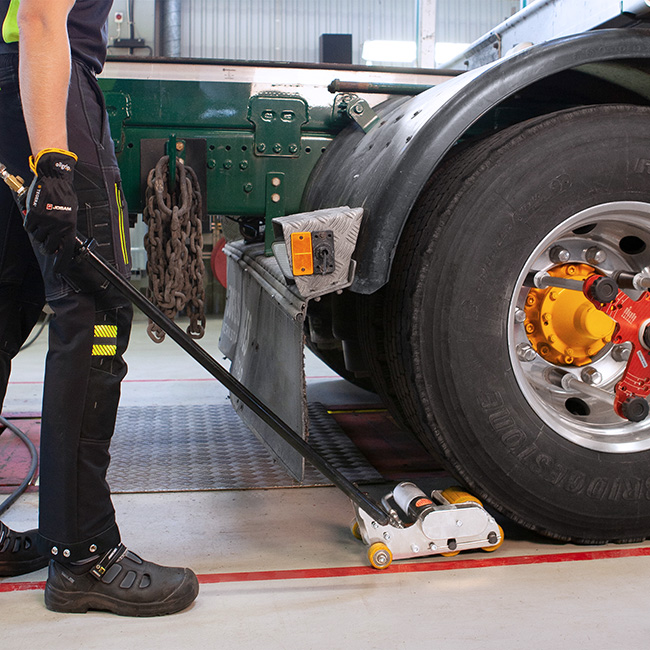 Technician using the vehicle roll mover